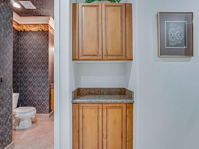 bathroom with vanity, toilet, and tile patterned flooring