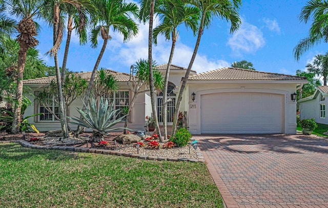 mediterranean / spanish-style home featuring a garage and a front yard