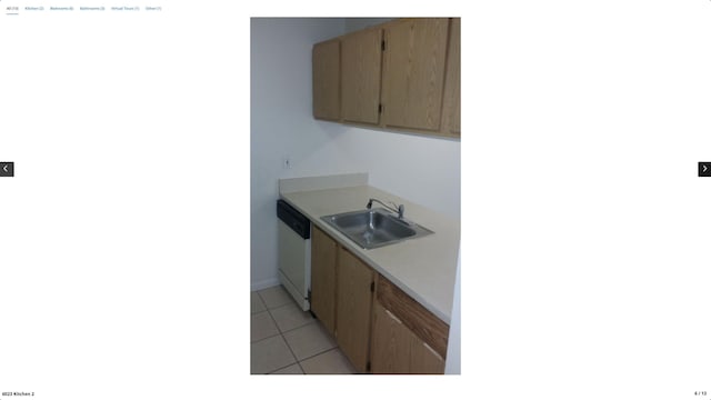 kitchen with light tile patterned flooring, dishwasher, and sink