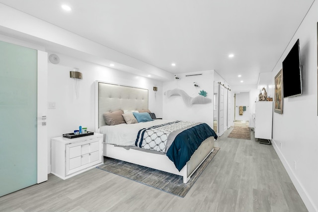 1155 Hillsboro Mile Unit 202, Hillsboro Beach, FL 33062 - bedroom with a barn door and light wood-type flooring