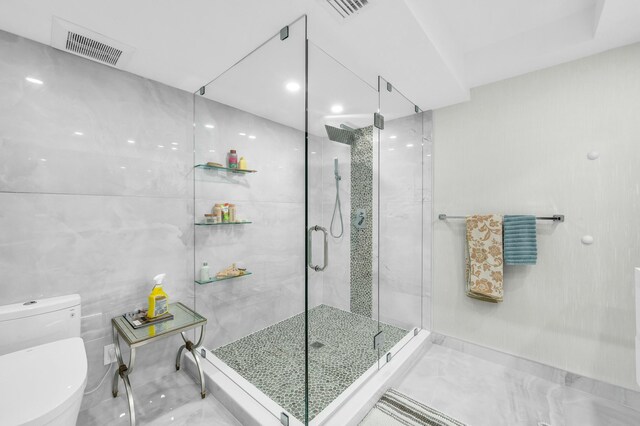 1155 Hillsboro Mile Unit 202, Hillsboro Beach, FL 33062 - bathroom with an enclosed shower, tile walls, and toilet