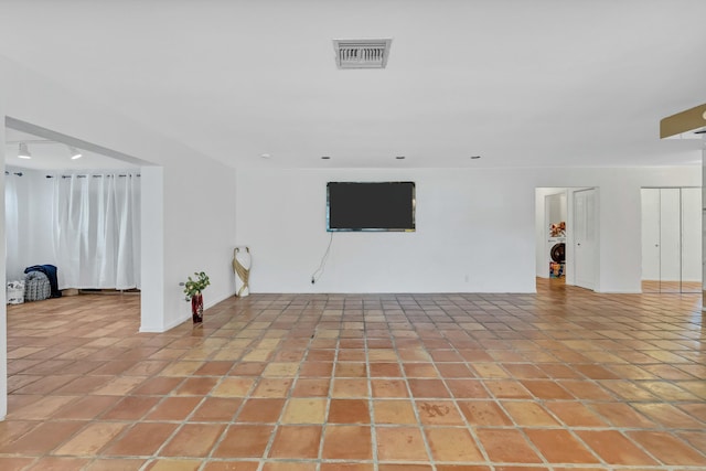 empty room with washer / dryer and light tile patterned floors