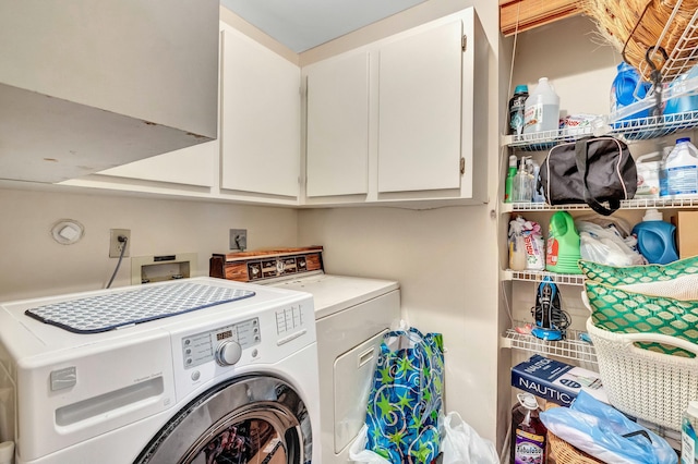 clothes washing area with cabinets and washer and clothes dryer