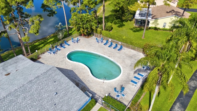 view of pool featuring a lawn, a patio, and a water view