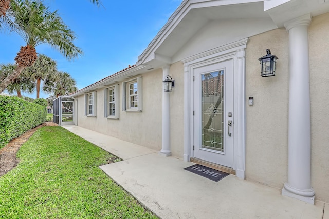 view of exterior entry with a yard