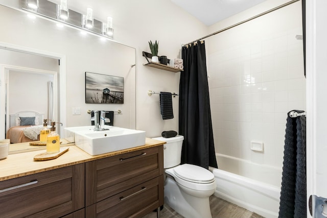 full bathroom featuring hardwood / wood-style flooring, toilet, vanity, and shower / bath combo with shower curtain