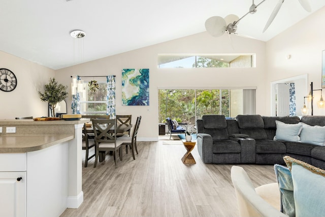 living room featuring ceiling fan, lofted ceiling, and light hardwood / wood-style flooring