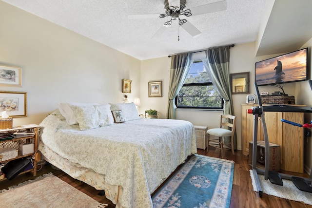 bedroom with ceiling fan, dark hardwood / wood-style floors, and a textured ceiling