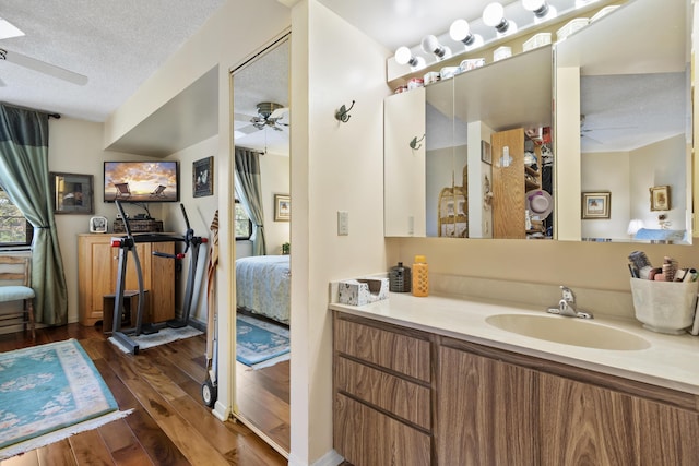 bathroom featuring vanity, hardwood / wood-style floors, a textured ceiling, and ceiling fan