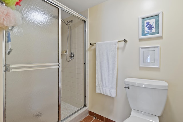 bathroom with a shower with shower door, tile patterned floors, and toilet