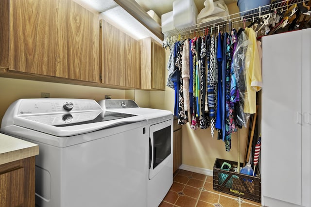 washroom featuring washer and clothes dryer, cabinets, and dark tile patterned floors