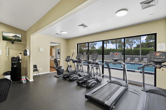 exercise room with lofted ceiling and a healthy amount of sunlight