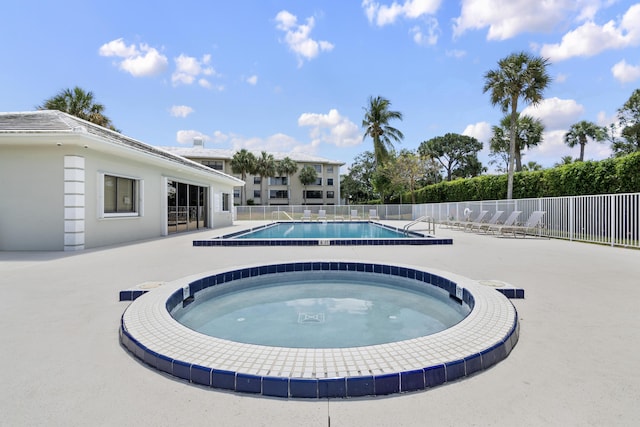 view of pool featuring a hot tub and a patio area