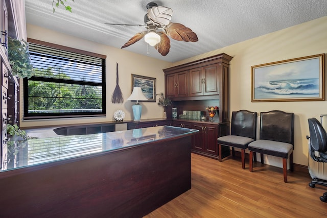 office featuring ceiling fan, a textured ceiling, and light wood-type flooring