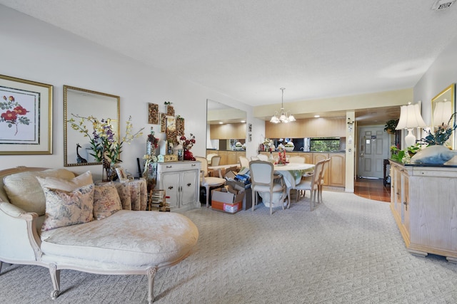 carpeted living room featuring a notable chandelier and a textured ceiling