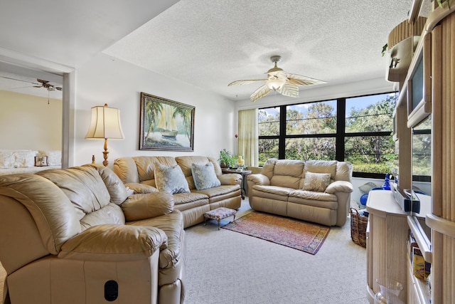 living room with ceiling fan, light carpet, and a textured ceiling