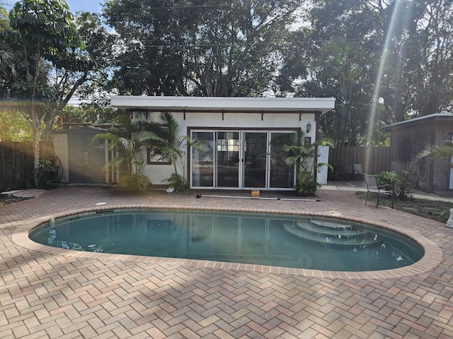 view of pool with a storage shed and a patio area