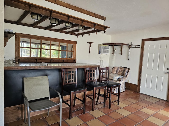 interior space with tile patterned floors and beam ceiling