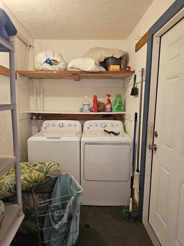 clothes washing area with washer and dryer and a textured ceiling