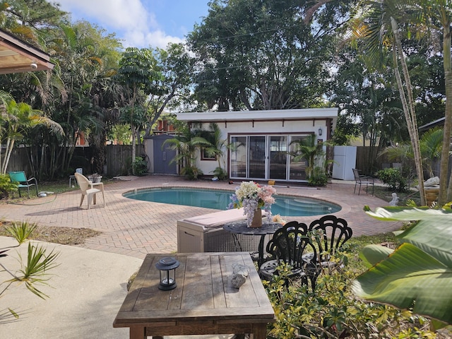 view of swimming pool featuring an outdoor structure and a patio area