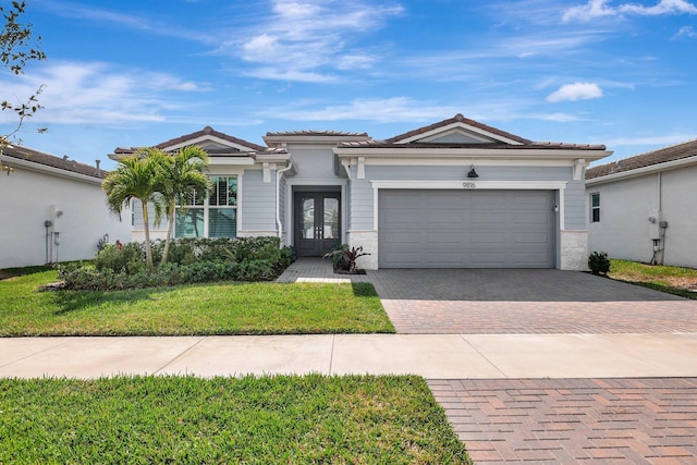 view of front facade with french doors, a garage, and a front yard