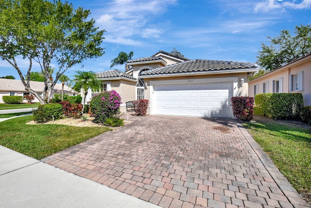 view of front of property featuring an attached garage, a tiled roof, decorative driveway, stucco siding, and a front yard