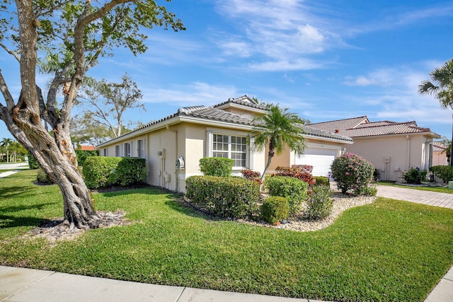 single story home featuring a garage, a tiled roof, decorative driveway, a front yard, and stucco siding