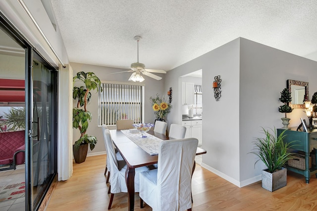 dining room with ceiling fan, a textured ceiling, and light wood-type flooring