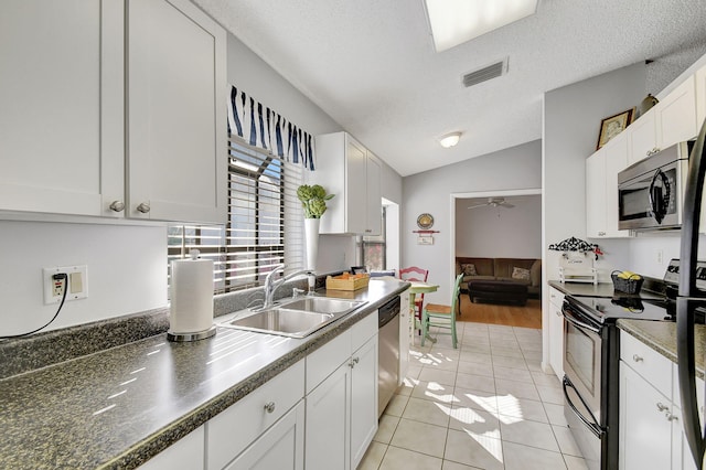 kitchen with lofted ceiling, appliances with stainless steel finishes, sink, and white cabinets