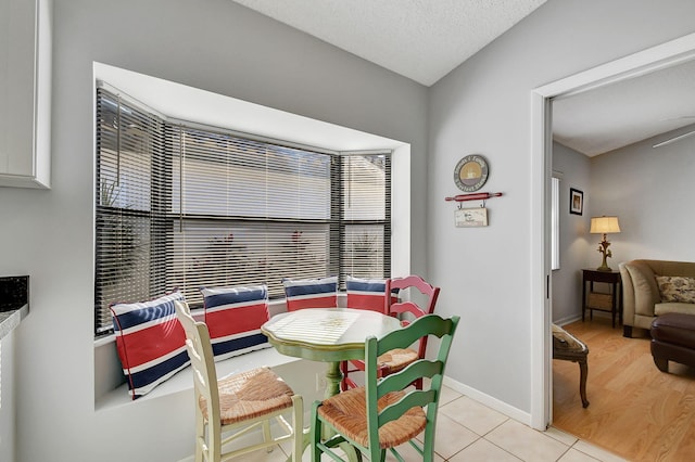 dining room featuring a textured ceiling and light tile patterned floors