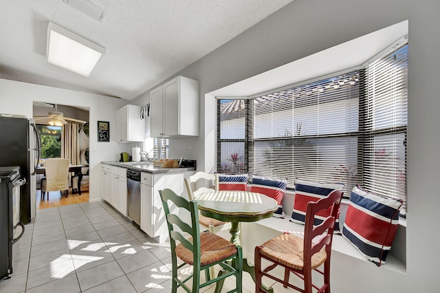 kitchen with light tile patterned flooring, white cabinetry, ceiling fan, stainless steel appliances, and a textured ceiling