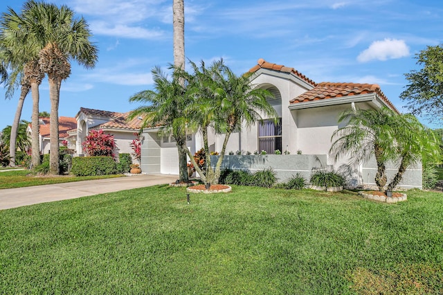 mediterranean / spanish-style house featuring a garage and a front yard