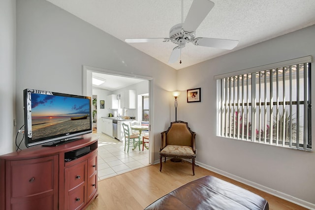 sitting room featuring ceiling fan, lofted ceiling, a textured ceiling, and light hardwood / wood-style flooring