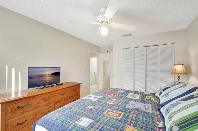 bedroom with ceiling fan, a closet, and a textured ceiling