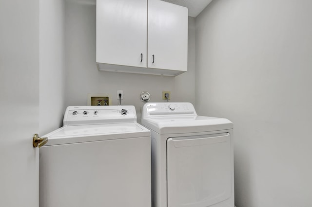 washroom featuring washing machine and dryer and cabinets