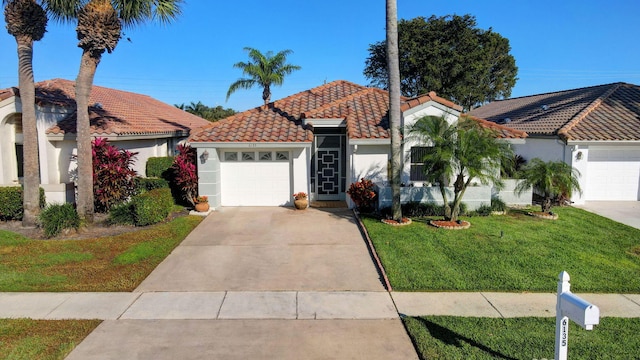 mediterranean / spanish-style home with a garage and a front lawn