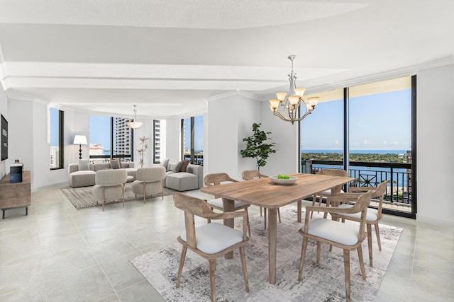 dining room with an inviting chandelier, ornamental molding, floor to ceiling windows, and a water view