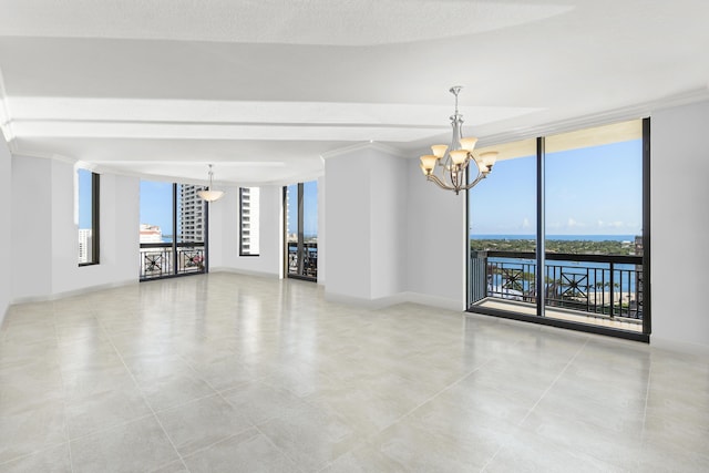 spare room featuring a notable chandelier, crown molding, and floor to ceiling windows