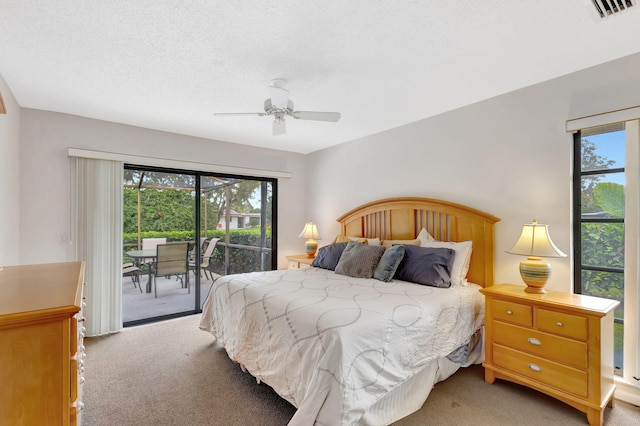 bedroom featuring ceiling fan, light colored carpet, access to exterior, and a textured ceiling