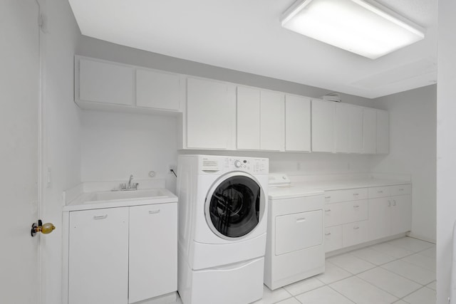 washroom featuring cabinets, washing machine and dryer, sink, and light tile patterned floors