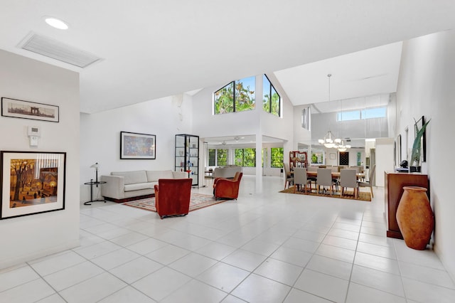 living room with an inviting chandelier, a towering ceiling, and light tile patterned flooring