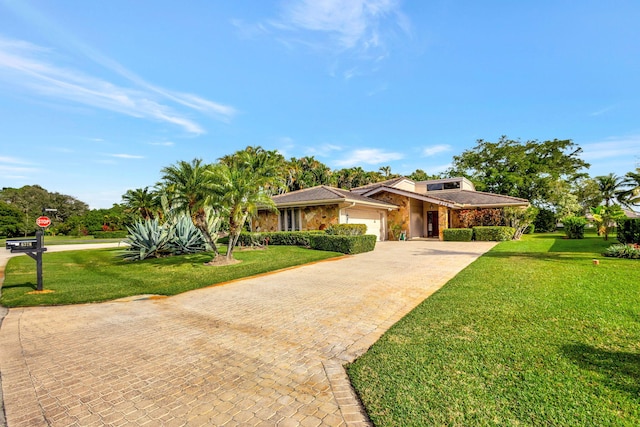 view of front of property with a garage and a front lawn