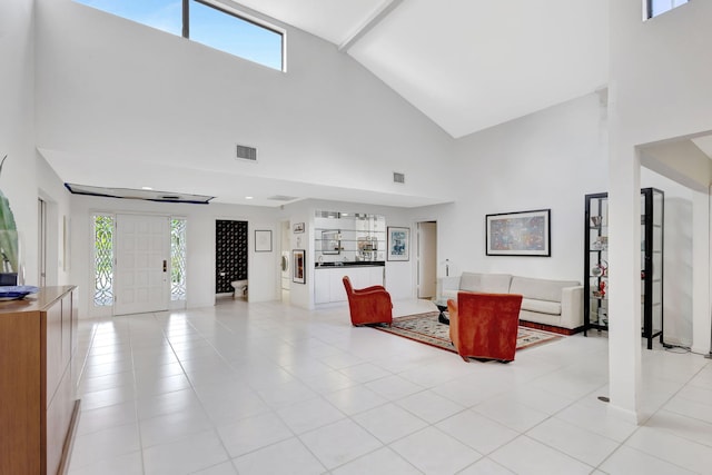 tiled living room featuring a towering ceiling and a wealth of natural light