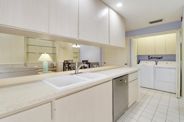 kitchen featuring sink, light tile patterned floors, washer and clothes dryer, and dishwasher