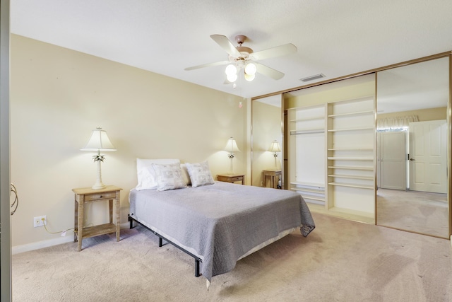 carpeted bedroom featuring ceiling fan and a closet