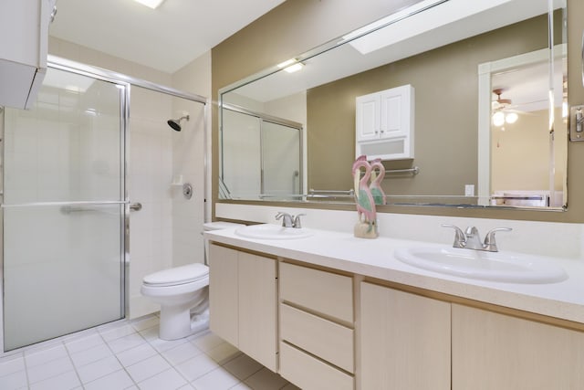 bathroom featuring a shower with door, vanity, tile patterned floors, and toilet