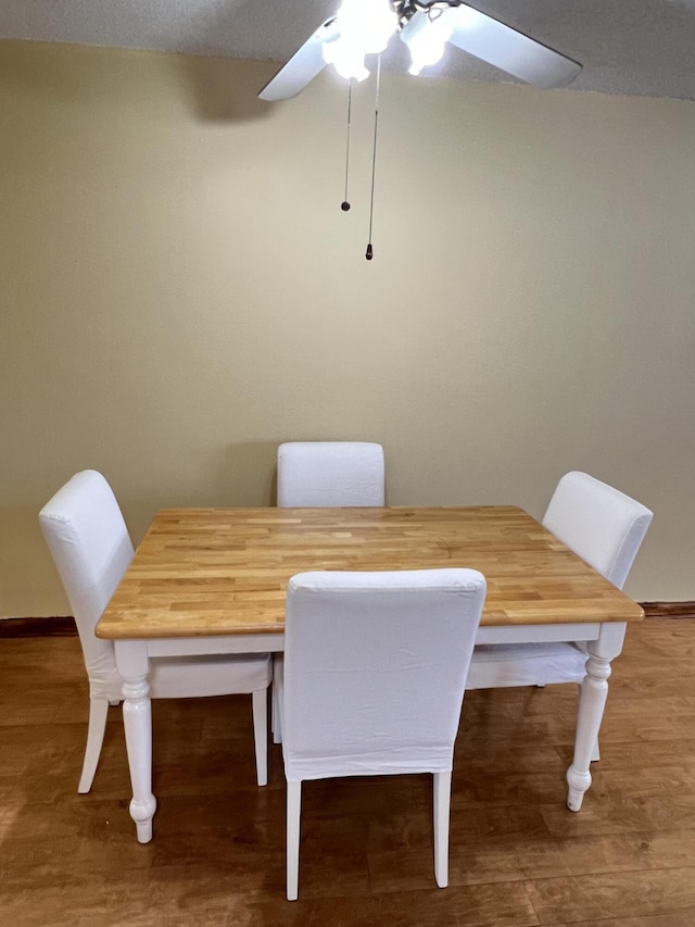 dining area with hardwood / wood-style floors and ceiling fan