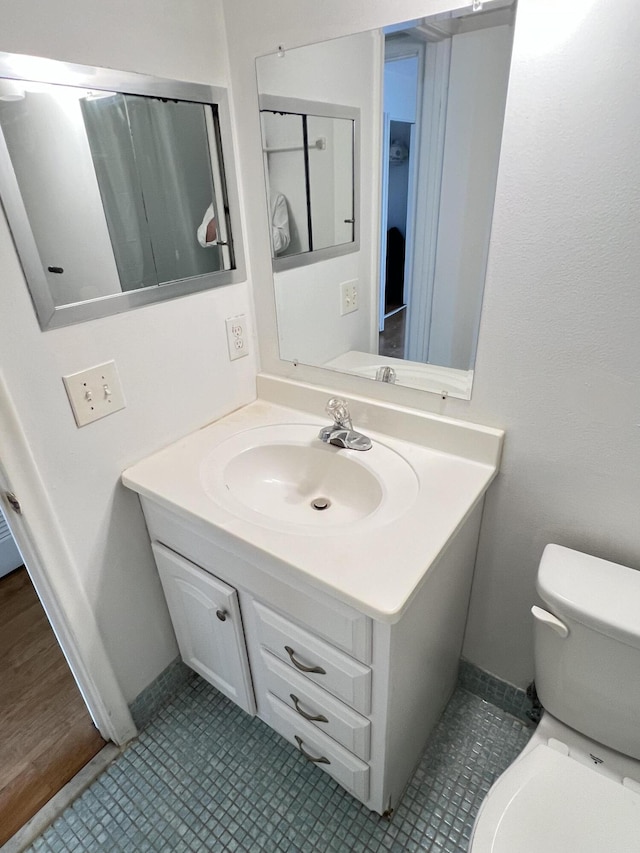 bathroom featuring tile patterned floors, vanity, and toilet