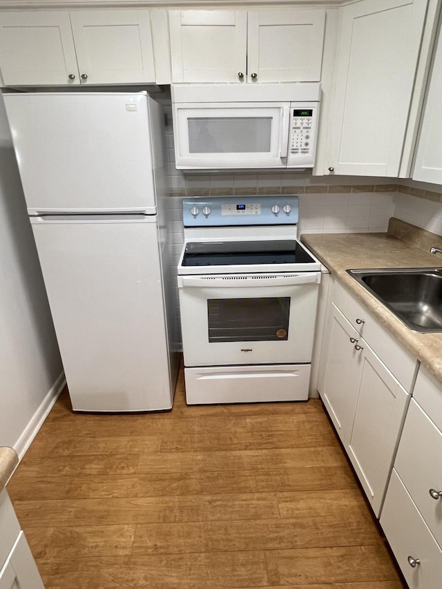 kitchen featuring white cabinetry, white appliances, sink, and light hardwood / wood-style flooring