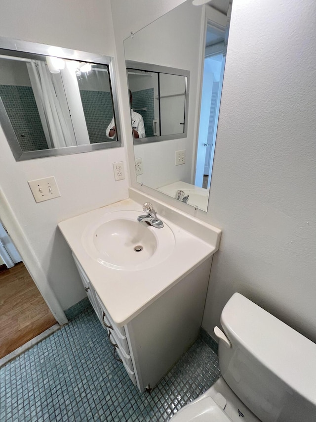 bathroom featuring vanity, toilet, and tile patterned flooring